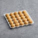 A tray of Simply Cuisine Mac and Cheese Bites on a gray surface.