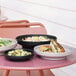 Three Cal-Mil black melamine bowls of food on a table.
