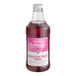 A bottle of Monin Brilliance Dragon Fruit Pink Energy Concentrate with a pink label filled with red liquid.