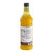 A close up of a Monin Yuzu Pineapple flavoring syrup bottle filled with orange liquid.