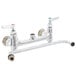 A chrome T&S wall mount pantry faucet with two handles and a swing nozzle.