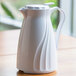 A white Service Ideas Twist 'N' Serv coffee carafe on a table.