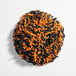 A round pile of orange and black Halloween-themed sprinkles.