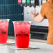 A clear plastic cup filled with red fruit punch and ice, branded with the Hometown Provisions logo.