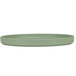 A close-up of a green Cal-Mil round melamine plate with a low rim.