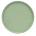 A close-up of a green Cal-Mil melamine plate with a round rim.