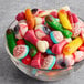 A glass bowl filled with assorted gummy candies shaped like body parts such as eyeballs, fingers, and brains.