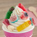 A cup of soft serve ice cream topped with assorted Vidal gummy candies shaped like body parts such as fingers, brains, and eyeballs.