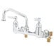 A chrome T&S wall mount pantry faucet with two handles.