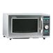 A close-up of a stainless steel Sharp medium-duty commercial microwave with a dial control and black rectangular buttons.