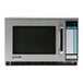 A close up of a silver Sharp commercial microwave with a black door and digital display.