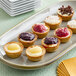 A plate of Cuisine Innovations Mini Assorted Cheesecakes on a table at a catering event.