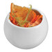 A white round porcelain mini dish filled with orange and lime slices.