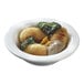 A Solia white porcelain mini dish filled with food and sauce on a table.
