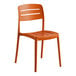 A terracotta-colored resin side chair with a slatted back and seat.