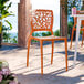 A terracotta-colored resin side chair with a webbed back design.
