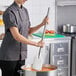A 36-inch stainless steel paddle being used to stir a large pot in a commercial kitchen.