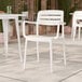 A white resin arm chair with a slat back design, suitable for outdoor or indoor seating.