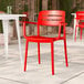 A red resin arm chair with a slat back design.