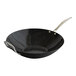 A black wok with a silver handle.