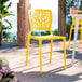 A yellow resin side chair with a webbed back design.