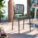 A brown resin side chair with a webbed back design, suitable for outdoor use.