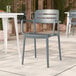 A gray resin arm chair with a slat back design, suitable for outdoor use.