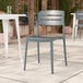 A gray resin side chair with a slat back design, suitable for outdoor or indoor use.