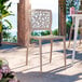 A sandy taupe resin side chair with a webbed back design.