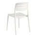 A white resin side chair with a slatted back and seat.