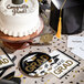 A round paper plate with a graduation theme and the words 'You Did It GRAD' in gold and black.