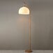 A 70-inch floor lamp with a wood-tone finish, a white paper shade, and a curved design.