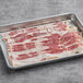 A tray of Hatfield Chef Choice buffet bacon slices on a gray surface.