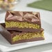 A white plate with a chocolate bar made with Kontos shredded kataifi dough and green filling.