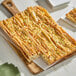 A rectangular piece of food on a wooden board.