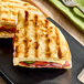 A pre-grilled panini sandwich made with Kontos 8-inch panini bread, filled with deli meat, cheese, and vegetables.