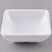 A white square Carlisle ramekin on a gray surface.