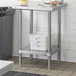 A stainless steel adjustable undershelf installed on a 24-inch by 24-inch work table.