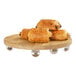 A group of croissants on a Cal-Mil oak wood display stand.