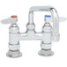 A T&S chrome deck-mount faucet with two handles and two faucets.
