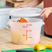 A translucent 12-quart round polypropylene food storage container with a lid and red measurement markings.