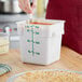 A white square polypropylene food storage container with green measurement markings and a green lid, holding up to 4 quarts or 3.5 liters.