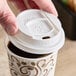 A person's hands holding a Dixie reclosable sliding white paper lid on a coffee cup.