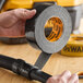 A roll of black DeWalt ultra-tough duct tape being applied to a hose connection.
