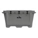 A grey Grizzly Cooler with black handles on a table outdoors.