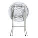 A round, granite white plastic folding table with gray metal legs in a folded position.