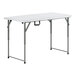 A white rectangular Lancaster Table & Seating bi-folding table with metal legs.