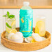 A bottle of Smartfruit Restart Lemonade Refresher beverage concentrate is displayed on a wicker tray with lemon-themed drinks and frozen treats.