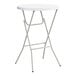A round, white, bar-height folding table with gray metal legs.
