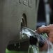 A person pouring water into a Grizzly outdoor cooler.